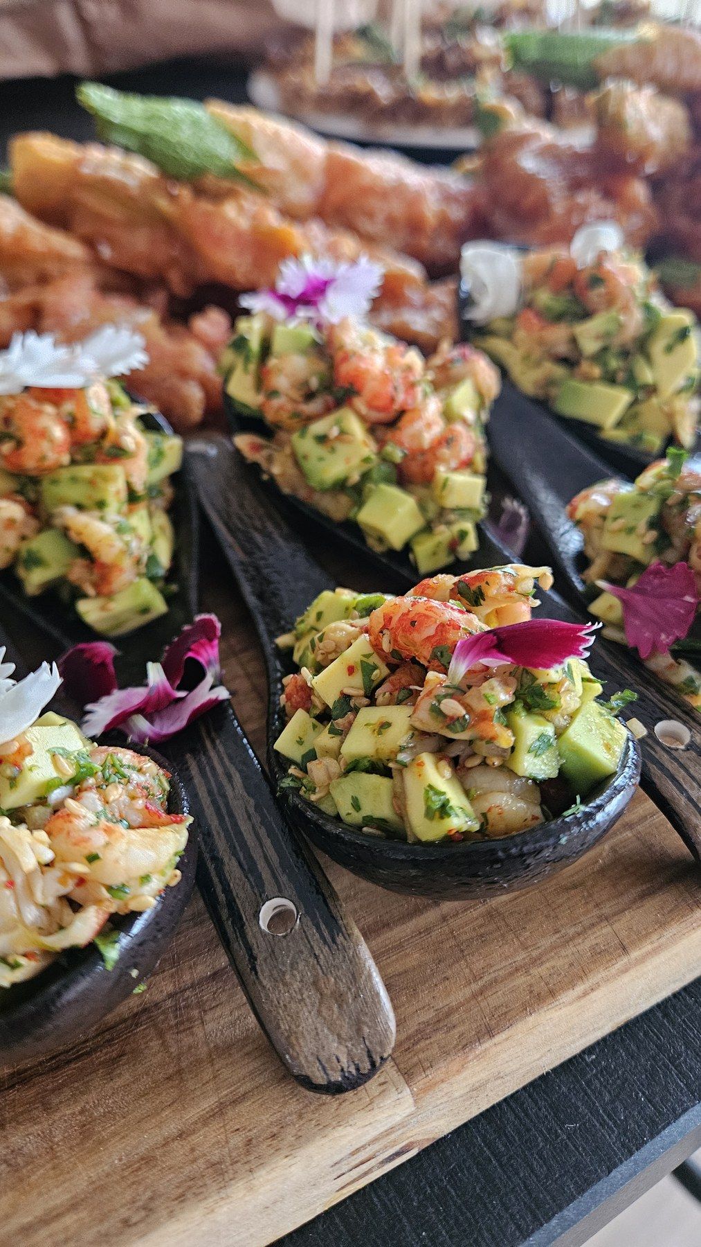 Bouchées avocat et crevette servies en cuillères de dégustation.
