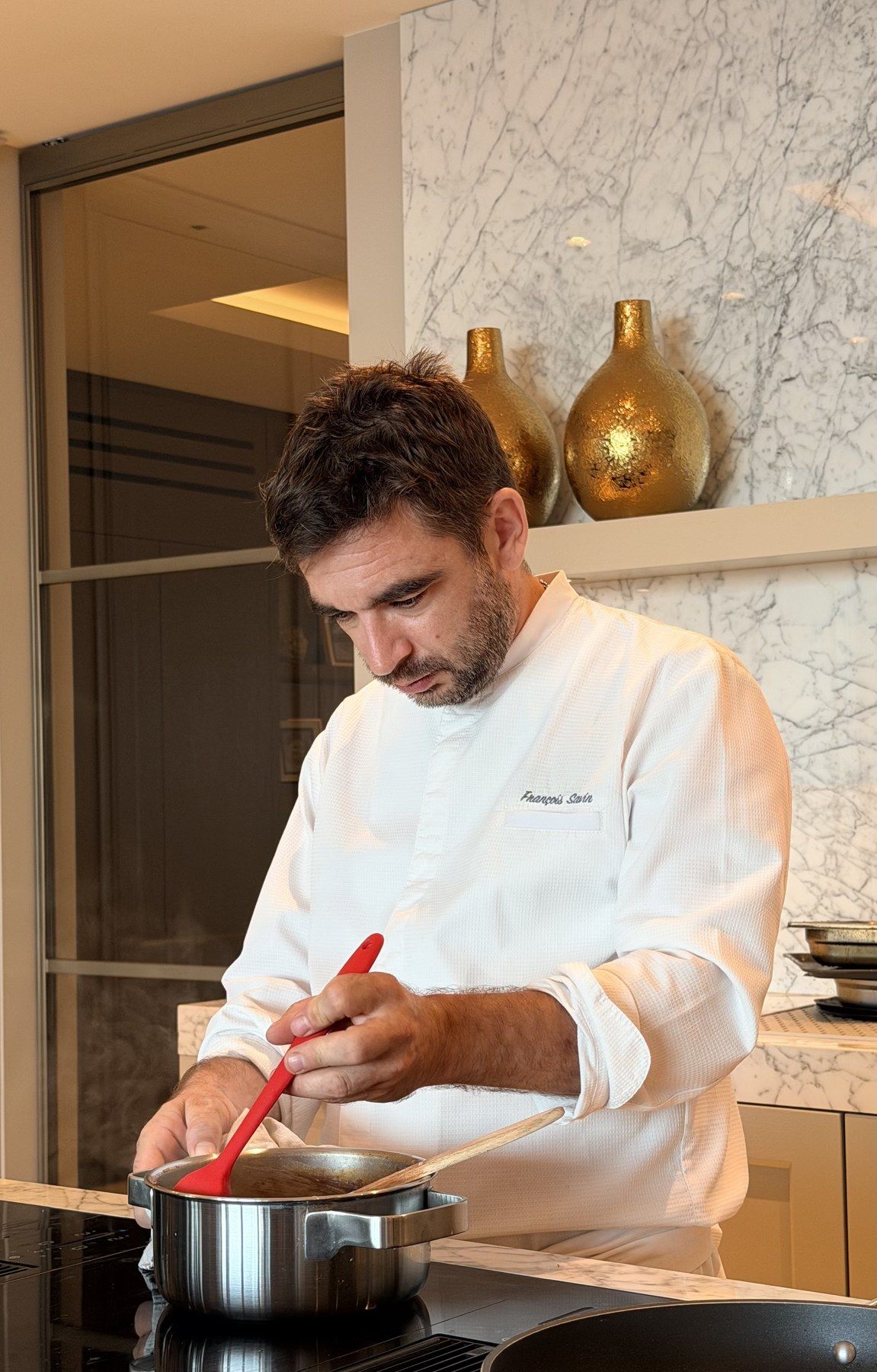 Le chef travaille une sauce en cuisine de villa.