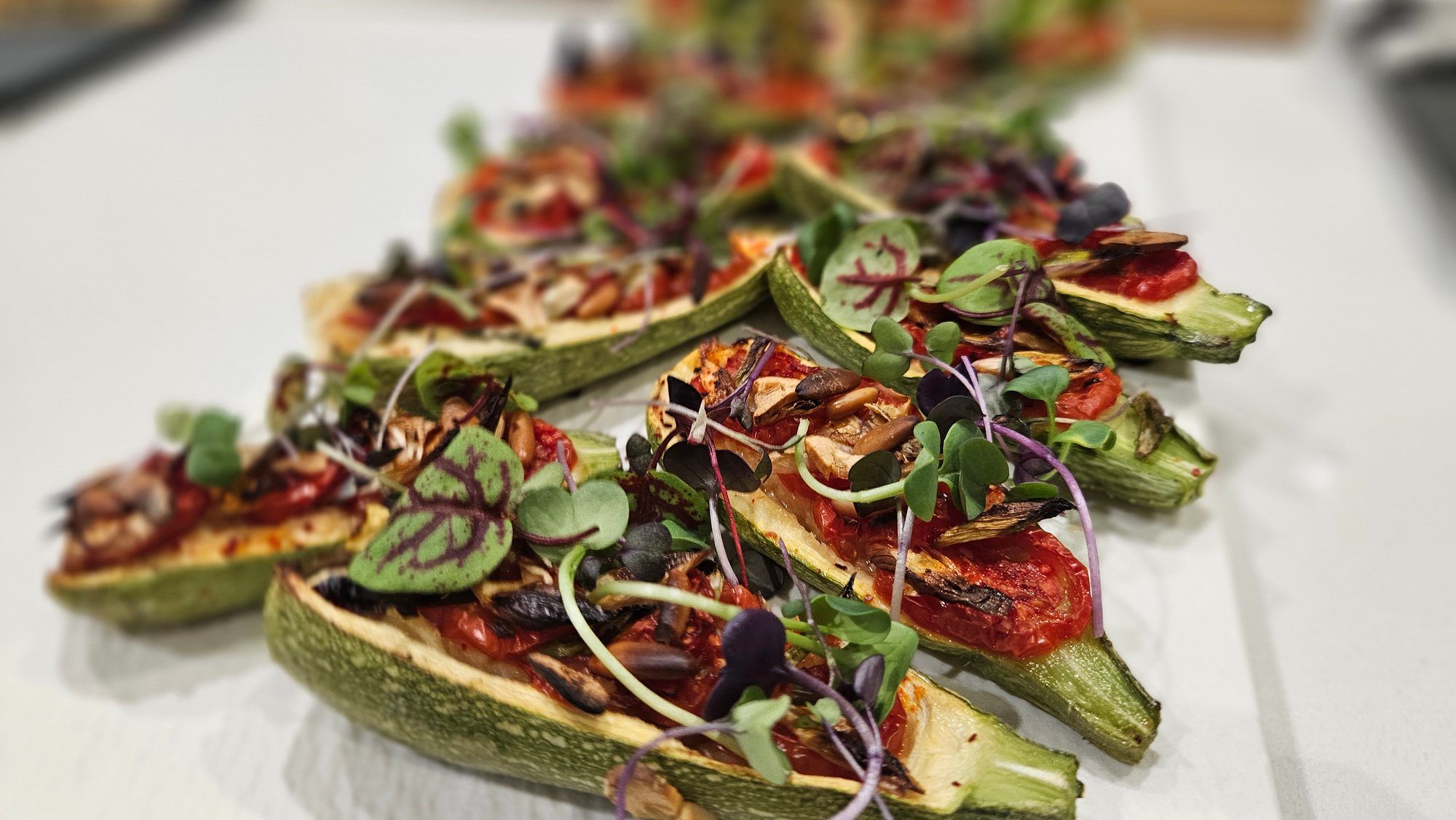 Courgettes farcies aux tomates et micro-pousses.