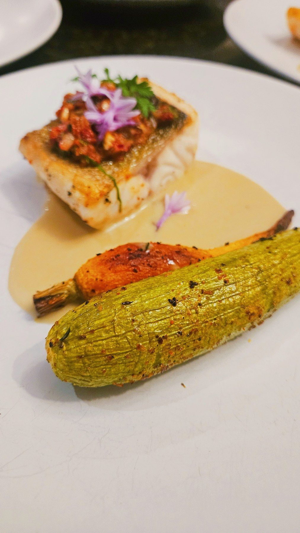 Filet de poisson gratiné, courgette rôtie et sauce crémée.