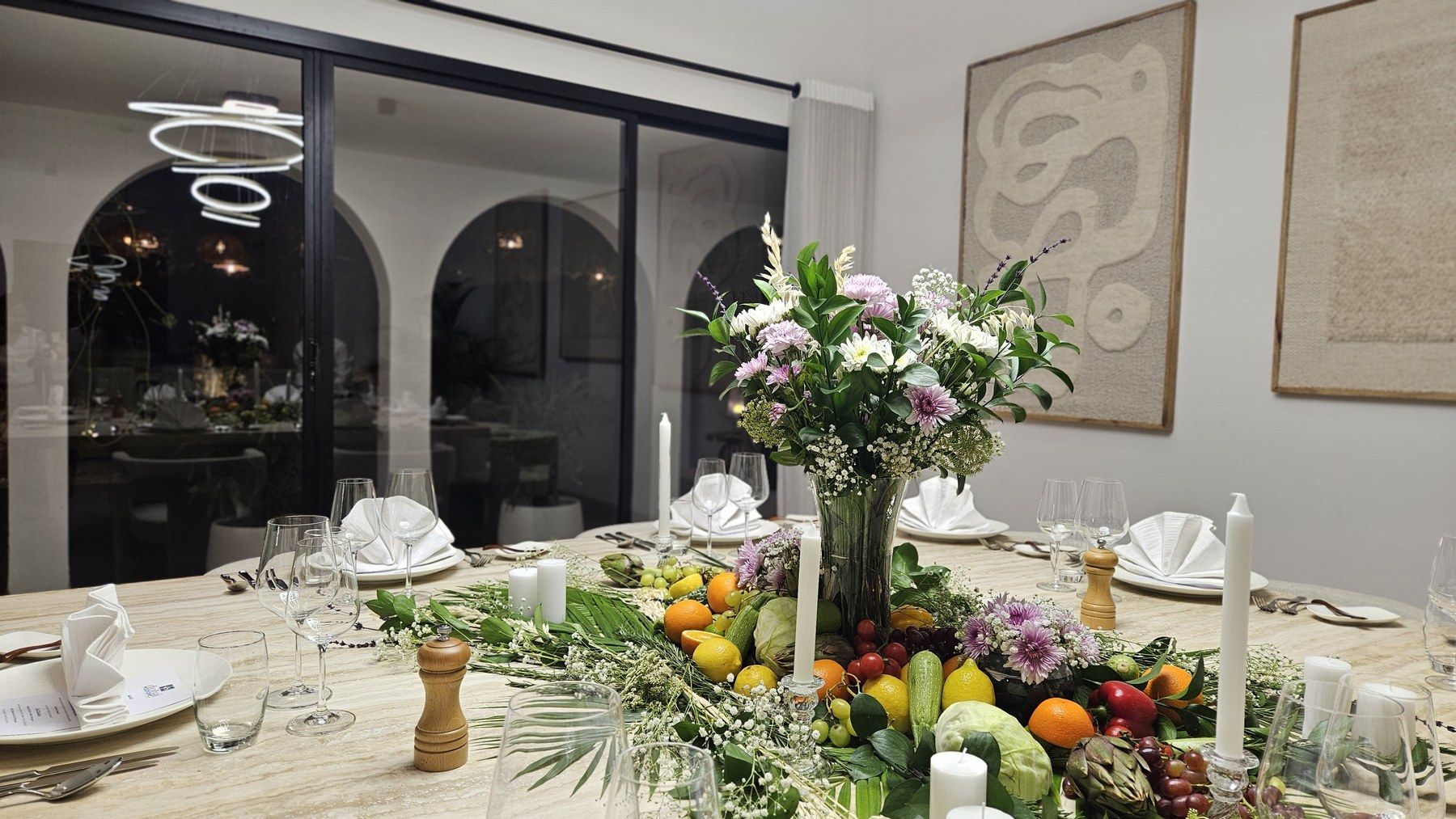 Table en marbre décorée de fruits, de fleurs et de chandelles.